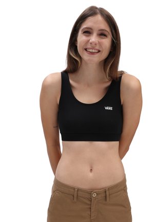 Black stretch fabric sports bra with wide straps and a rounded neckline. Features a white "VANS" logo on the left side. Seamless design.