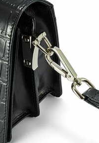 Czarna skórzana torebka z teksturą krokodyla, z metalowym zapięciem w kolorze srebra i elementami do mocowania.