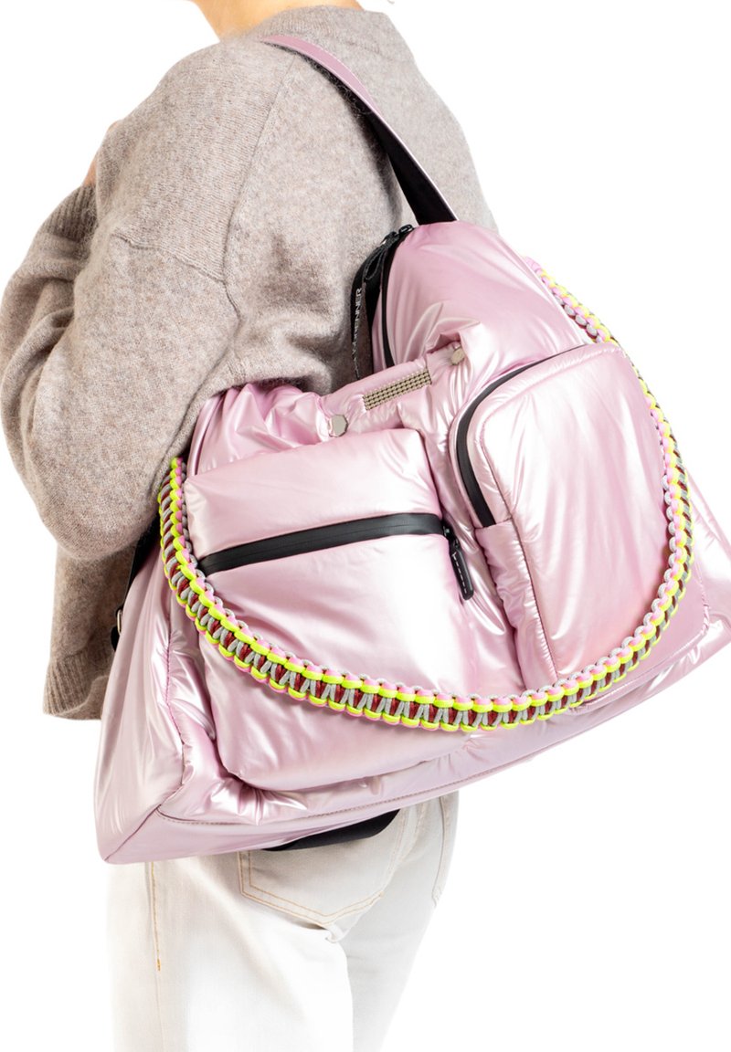Roze gewatteerde rugzak met een glanzende afwerking, voorzien van zwarte ritsen en een kleurrijke gevlochten schouderband. Grote voorzak met een rits.