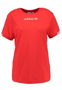 Červené bavlněné tričko s kulatým výstřihem, krátkými rukávy a bílým logem "adidas". Na okraji každého rukávu se nacházejí tři bílé pruhy.