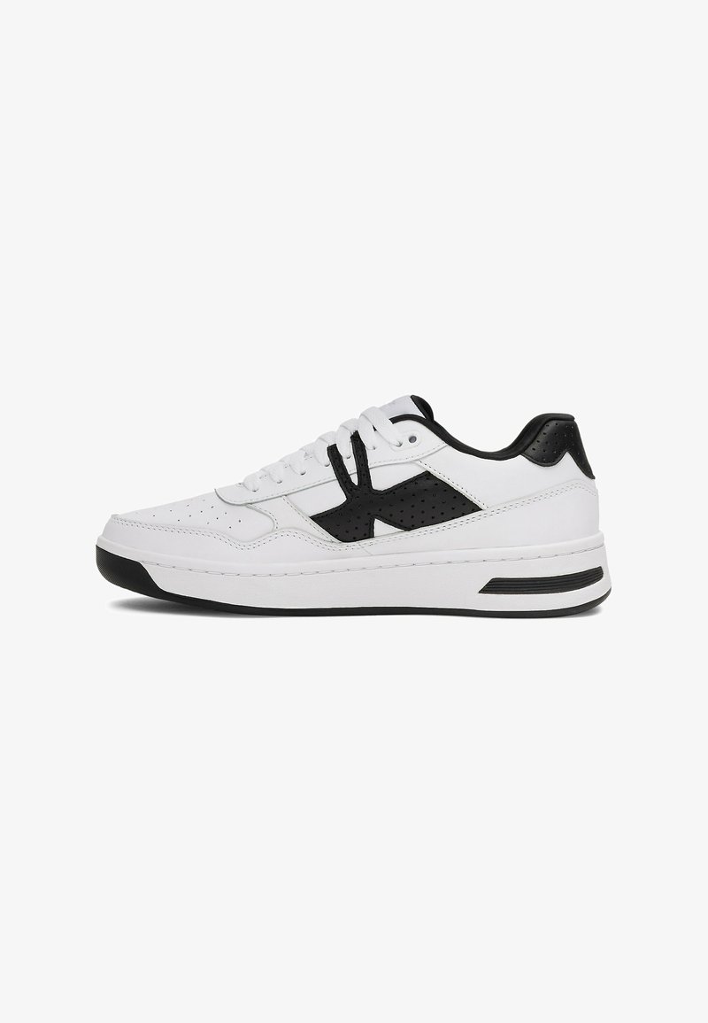 Witte sneaker met zwarte accenten, bovenwerk van gladleer, geperforeerde details aan de zijkanten, platte veters en een dikke rubberen zool.