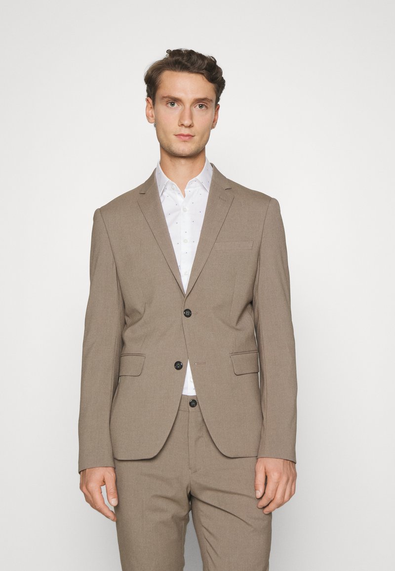 Brown tailored suit made of textured fabric, featuring a single-breasted jacket with two buttons and notch lapels, and matching trousers.