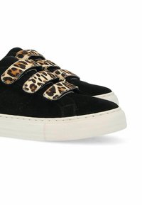 Black suede sneakers feature leopard print straps and white rubber soles. The design includes three velcro fastenings for easy adjustment.