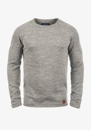 Lys grå strikket sweatshirt med rund hals, ribbede manchetter og et lille læderlogo-patch ved kanten. Blød tekstur med et subtilt mønster.
