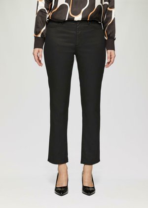 Zwarte broek met een slim fit, gemaakt van een gladde stof. Heeft een middelhoge taille en subtiele stiksels op de voorkant van de zakken. G gedragen met zwarte hakken.