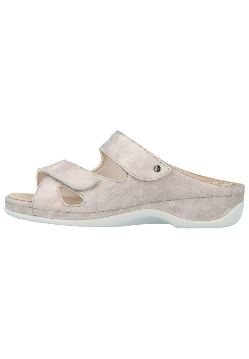 Beige suede slide sandals with open toe and cutout design, featuring a hook-and-loop strap and a white rubber sole.