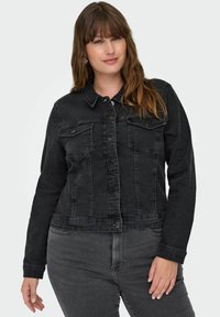 Svart denimjacka med krage, knäppning fram och två bröstfickor. Designen har en något kortad passform och textil med struktur.