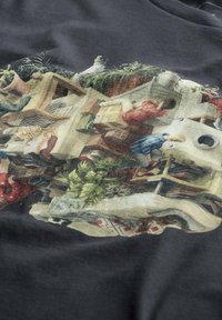 Grafische t-shirt met een gedetailleerde, kleurrijke illustratie van rommelige binnenruimtes, met verschillende texturen en vormen op een donkere stofachtergrond.