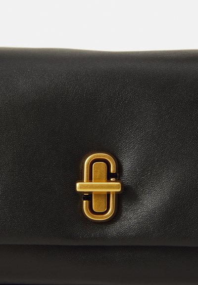 Bolso de cuero negro con una textura suave, con un cierre destacado en tono dorado y un diseño minimalista para un cierre seguro.
