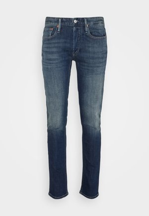 Dunkelblaue Jeans aus Denim mit Slim-Fit, leichtem Ausbleichen, traditionellem Fünf-Taschen-Design sowie einem Reißverschluss und einem Knopfverschluss.