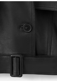 Sección de chaqueta de cuero negro con un botón negro y un cinturón ancho de cuero con una hebilla rectangular en el borde inferior.