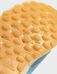 Podeszwa buta w jasnopomarańczowej gumie z sześciokątnymi wzorami przyczepności. Lekko teksturowana powierzchnia z wypukłymi elementami dla lepszego chwytu.