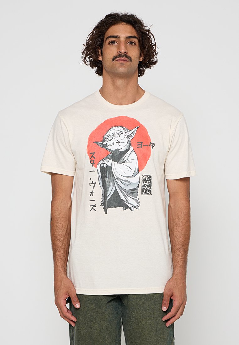 Crèmegekleurde katoenen t-shirt met een grafische print van een karakter met puntige oren, omringd door een rode cirkel en Japanse tekst.