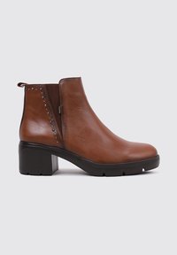 Botas de cuero marrón hasta el tobillo con puntera redondeada y tacón cuadrado, que presentan acentos de tachuelas en el costado y un panel elástico para facilitar su uso.