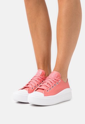Růžové kožené tenisky s bílou gumovou podrážkou, zaoblenou špičkou, šněrovacím designem a kovovými očky.