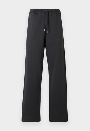 Čierne tepláky s voľným strihom, elastickým pásom a šnúrkou. Vyrobené z mäkkého materiálu, s dvoma bočnými švami a bez vreciek.