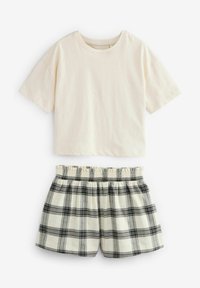 T-shirt in cotone a maniche corte beige chiaro abbinato a pantaloni corti a quadri bianco e nero con vita elastica e dettaglio arricciato.