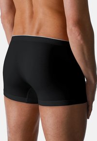 Boxer aderenti neri realizzati in tessuto morbido e liscio. Caratterizzati da una vestibilità aderente, gambe corte e una cintura a contrasto con un design sottile.