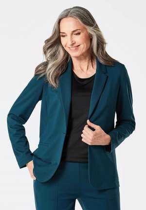 Donker teal op maat gemaakte blazer met een notch lapel, gecombineerd met een zwarte top. Glad materiaal met een gestructureerde pasvorm en minimalistisch ontwerp.
