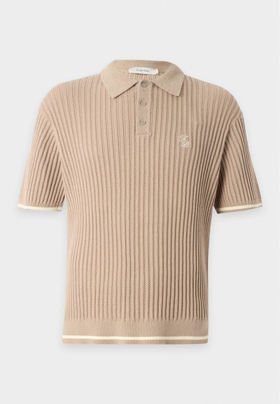 Polo en maille côtelée beige à manches courtes avec trois boutons, petit logo brodé sur la poitrine et finition blanche aux manches et à l'ourlet.