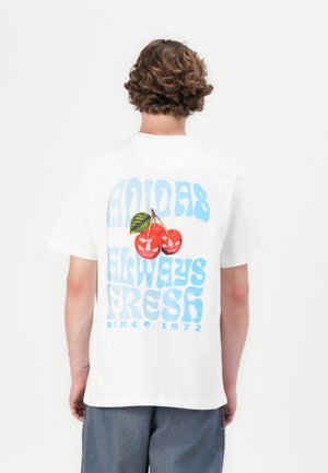 T-shirt de algodão branca com texto retro em azul e gráfico de cerejas vermelhas com folhas verdes; vista traseira. Ajuste casual, mangas curtas.