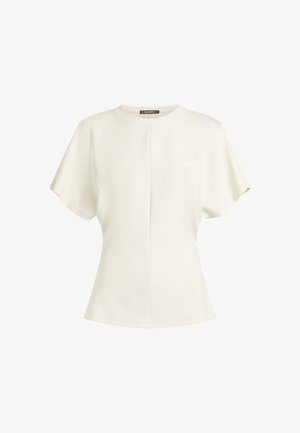 Top scurt cu mânecă scurtă de culoare crem, cu decolteu rotund, prezentând o cusătură centrală și un accent discret cu logo. Textură moale și siluetă relaxed.