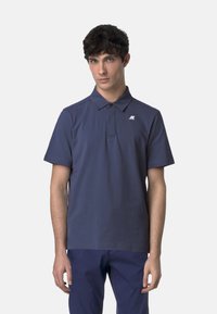 Námornícky polo tričko vyrobené z jemnej látky, s bodkovaným golierom, krátkymi rukávmi a malým logom na ľavej strane hrudníka.