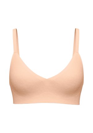 Seamless light beige wireless bra with adjustable straps and a smooth, molded cup design for comfort and support.