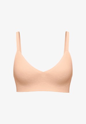 Seamless light beige wireless bra with adjustable straps and a smooth, molded cup design for comfort and support.