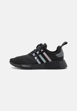 Czarny sneaker Adidas z wielokolorowymi paskami, czarną teksturowaną podeszwą, sznurowanym designem i pętelką z tyłu na pięcie.