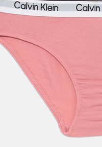 Rosa Baumwollslip von Calvin Klein mit einem weißen elastischen Bund, der mit schwarzem Branding versehen ist. Glatte Textur, mit genähten Kanten und einem tief sitzenden Schnitt.