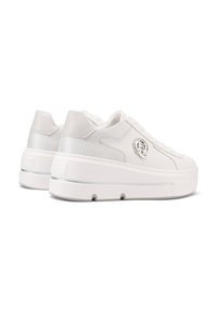 Baskets blanches avec une tige texturée, des matériaux mats et brillants contrastants, une semelle épaisse et une accentuation de logo circulaire sur le côté.