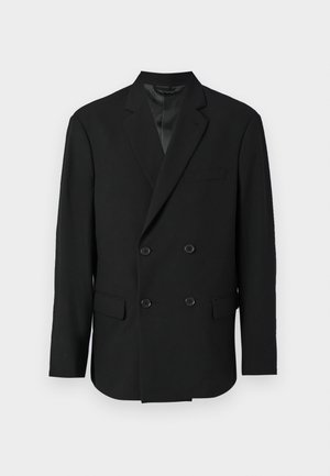 Blazer nero doppiopetto con sottogola in satin, due tasche frontali e rever a punta. Presenta cinque bottoni sul davanti.