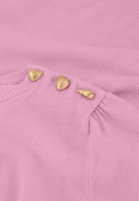 Roze gebreide trui met drie goudaccentknopen in de vorm van een hart, aardbei en schelp. Zachte textuur en geribbelde halslijn.