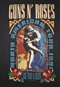 Sort bomulds t-shirt med et multicolor grafik af en figur, pigtråd, roser og tekst der læser "GUNS N' ROSES NORTH AMERICAN TOUR 1991."
