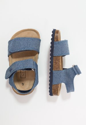 Sandales en denim bleu pour enfants avec deux brides réglables et une semelle style liège, vues de dessus et de côté sur fond blanc.