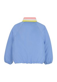 Lichtblauwe jas met een geribbeld kraag in roze, geel en wit. Heeft gebronzeerde mouwen en een afgeronde onderkant. Gestyled vanuit de achterkant.