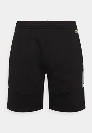 Czarne bawełniane szorty z elastycznym paskiem w talii, wyposażone w boczne akcenty i subtelne logo. Gładka faktura, długość sięgająca do kolan.