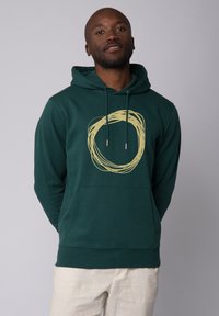 Grüne Kapuzenjacke aus weichem Stoff mit einem handgezeichneten gelben Wirbel-Design auf der Vorderseite, mit Kordelzügen und einer Kängurutasche.