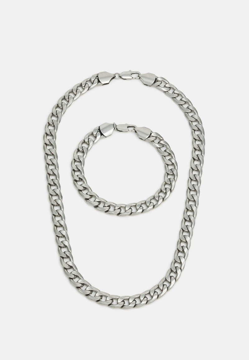 Metal kæde halskæde og armbånd sæt. Sølvfarve, tykke led, glat tekstur, med sikre låse. Begge stykker har et ensartet design.
