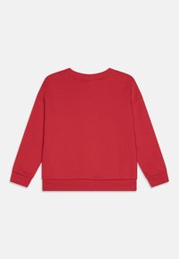 Sarkans krekls ar garām piedurknēm, apaļu kakla izgriezumu, rievotu piedurkņu galiem un apakšmalu. Izgatavots no mīksta kokvilnas auduma, ar vienkāršu krāsu dizainu.