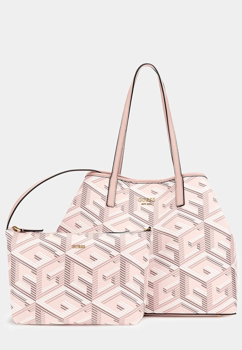 Sac cabas rose à motif géométrique avec pochette zippée assortie, tous deux ornés de logos dorés « GUESS » et anses doubles sur le sac.