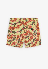 Shorts de bain colorés avec un fond jaune et un motif dynamique en zigzag et en diamant dans les tons rouge, vert et noir. Comprend une poche arrière.