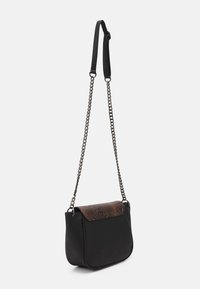 Černá ramenní taška se stříbrným řetízkem a klopou s hnědým vzorem hadí kůže, vystavená na bílém pozadí.