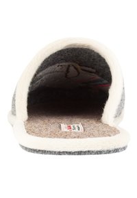 Gray felt slipper with white plush lining, open back design, beige insole, and a tag visible on the footbed. Soft texture throughout.