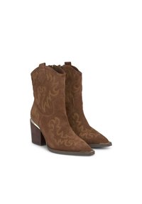 Botines de ante marrón con punteras afiladas, que presentan patrones decorativos de costura, un tacón grueso y cierre con cremallera lateral.
