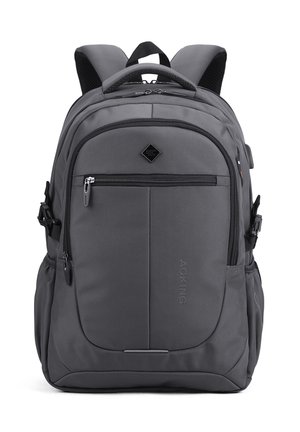 Sac à dos gris avec des bretelles rembourrées, plusieurs compartiments zippés, des poches latérales et une poignée supérieure, conçu pour un usage quotidien.
