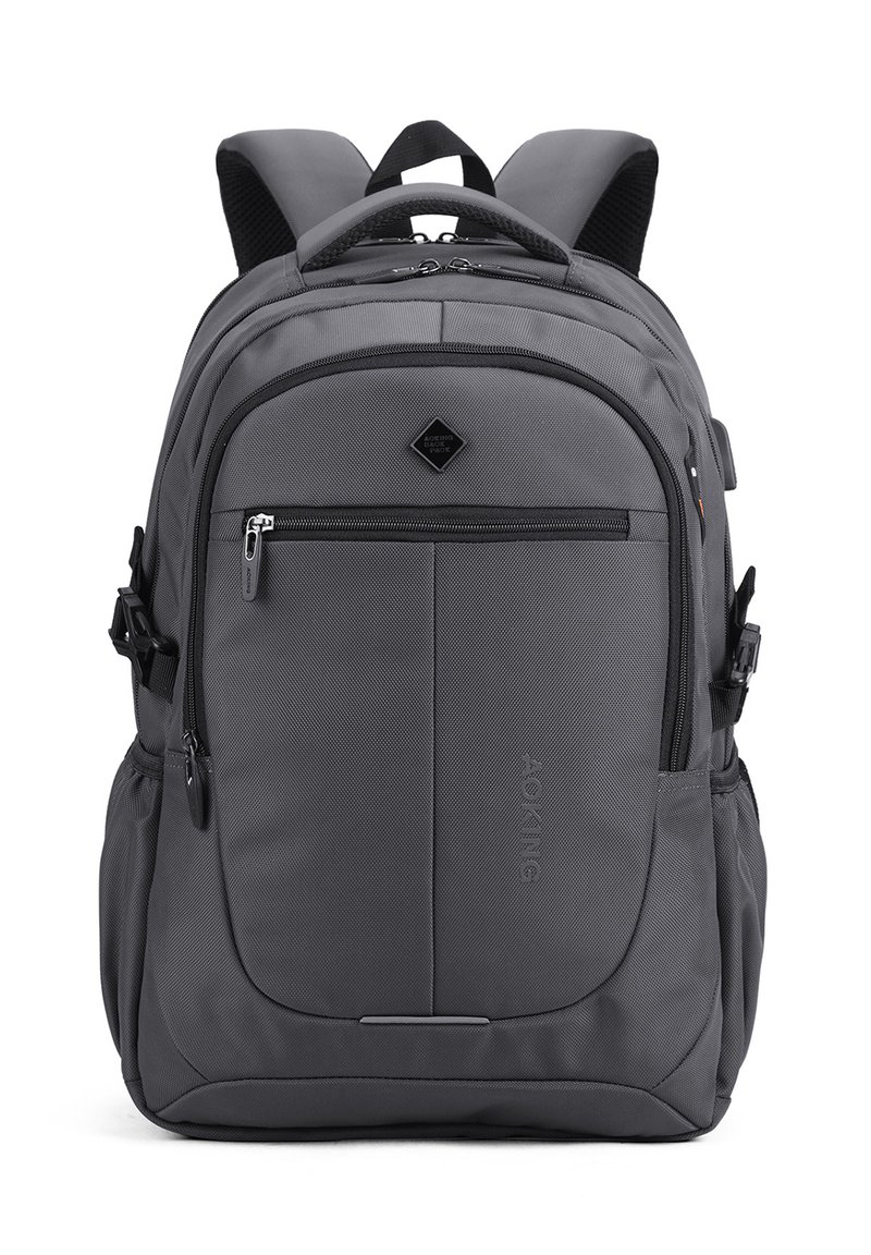 Zaino grigio con spallacci imbottiti, molteplici scomparti con zip, tasche laterali e una maniglia superiore, progettato per l'uso quotidiano.