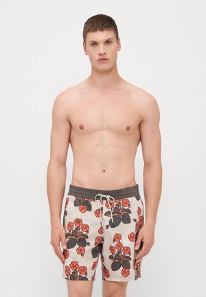 Bañador en color beige con un patrón floral que incluye flores rojas y hojas verdes, cintura elástica con cordón, diseño hasta las rodillas.