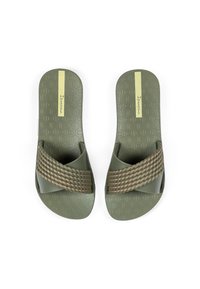 Grüne Sandalen mit einer strukturierten, gemusterten Innensohle und einem geflochtenen Riemen in einer helleren Farbausführung, ausgestattet mit einem kleinen Logo-Detail an der Seite.